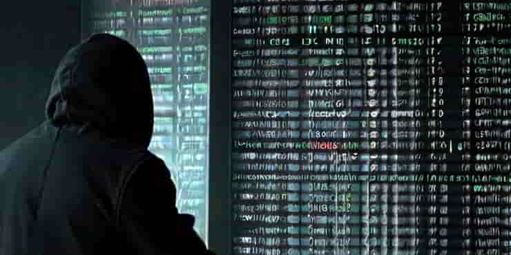 A hacker in a hoody staring at a screen full of data