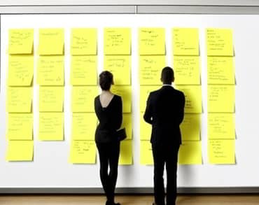 A man and woman organising post-it notes